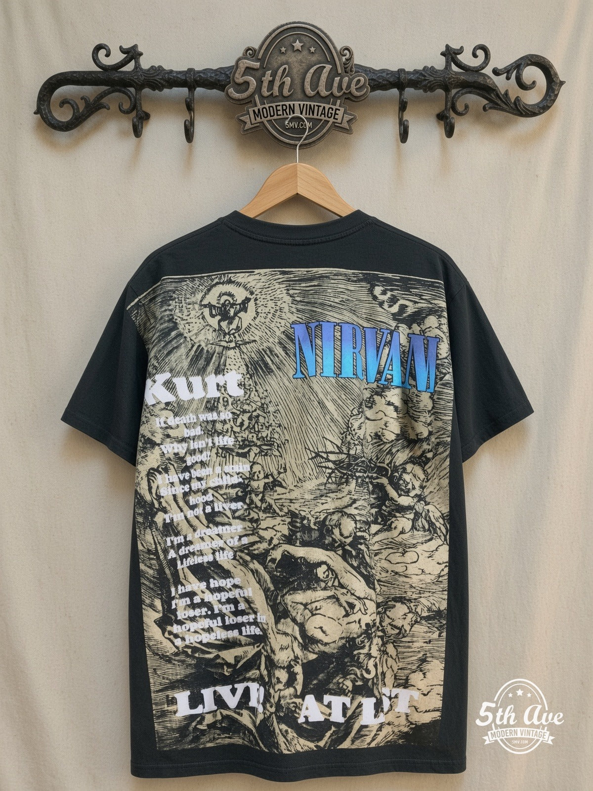 Kurt Cobain – Nirvana Live at Last – All Over Print – Vintage Band T-Shirt — back on locked cream ornate 5th Ave rack