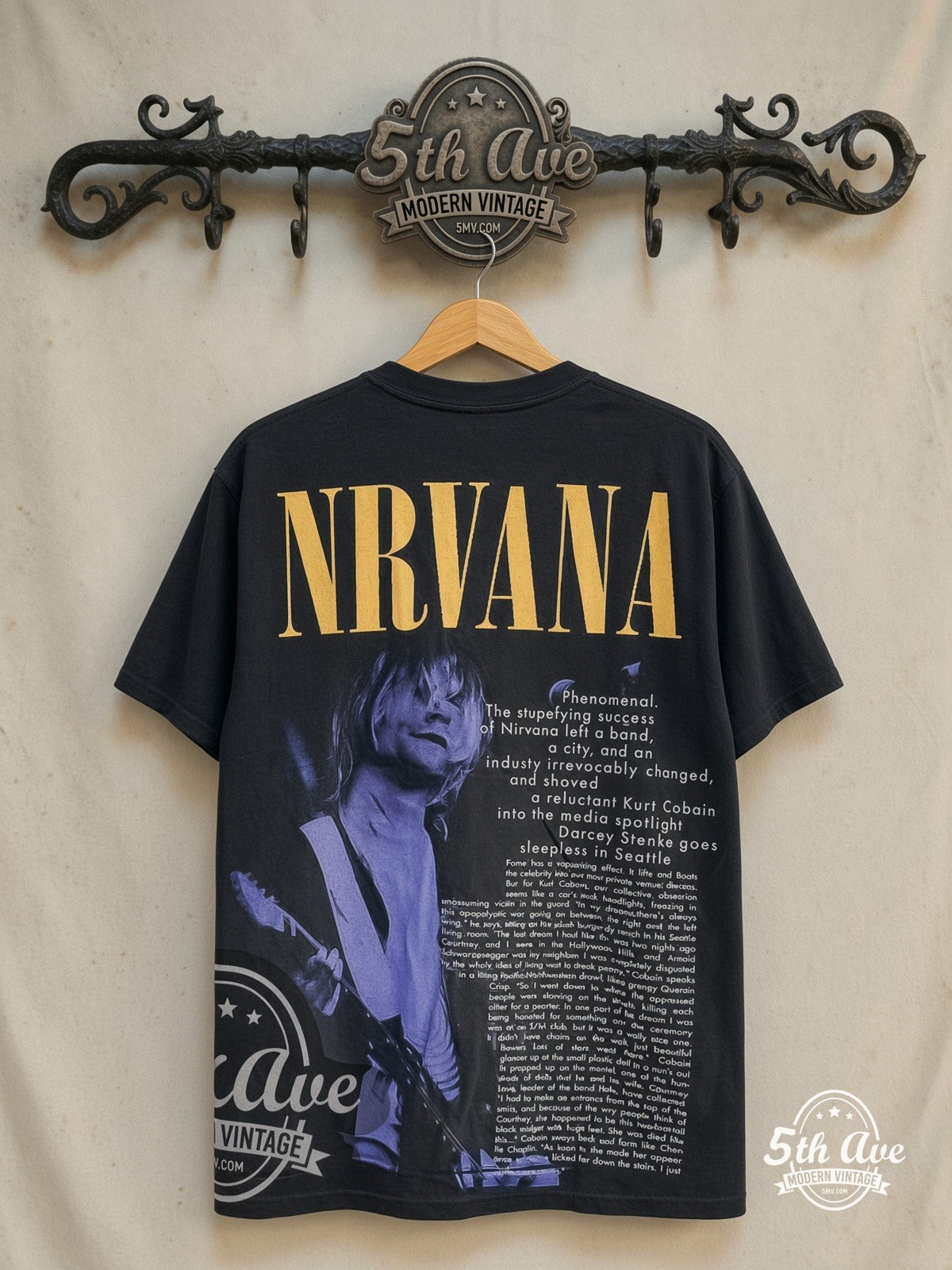 Nirvana – A City in the Dark 1967-1994 – All Over Print – Vintage Band T-Shirt — back on locked cream ornate 5th Ave rack