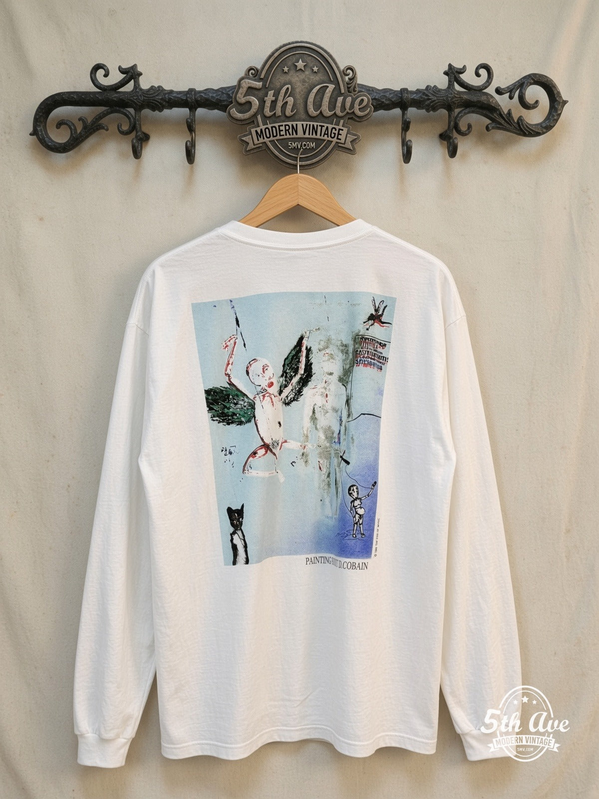 Kurt Cobain – Legacy Tribute – Vintage Band T-Shirt — back on locked cream ornate 5th Ave rack