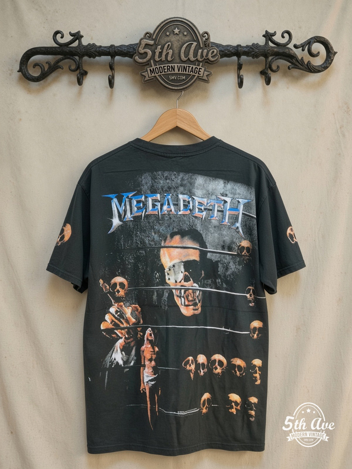 Megadeth – Vic Rattlehead Multi Skull All Over Print – Vintage Band T-Shirt — back on locked cream ornate 5th Ave rack