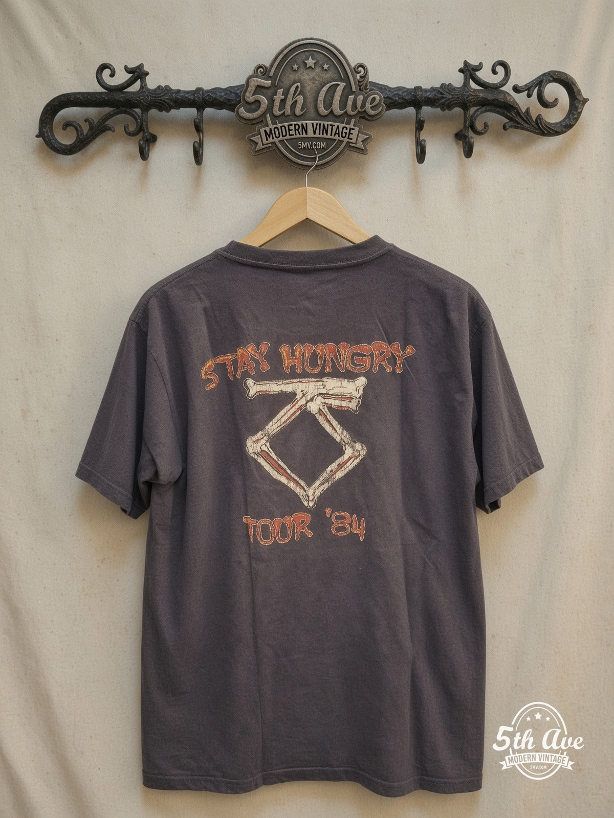 Twisted Sister – Stay Hungry Dee Snider Biting Bone – Vintage Band T-Shirt — back on locked cream ornate 5th Ave rack