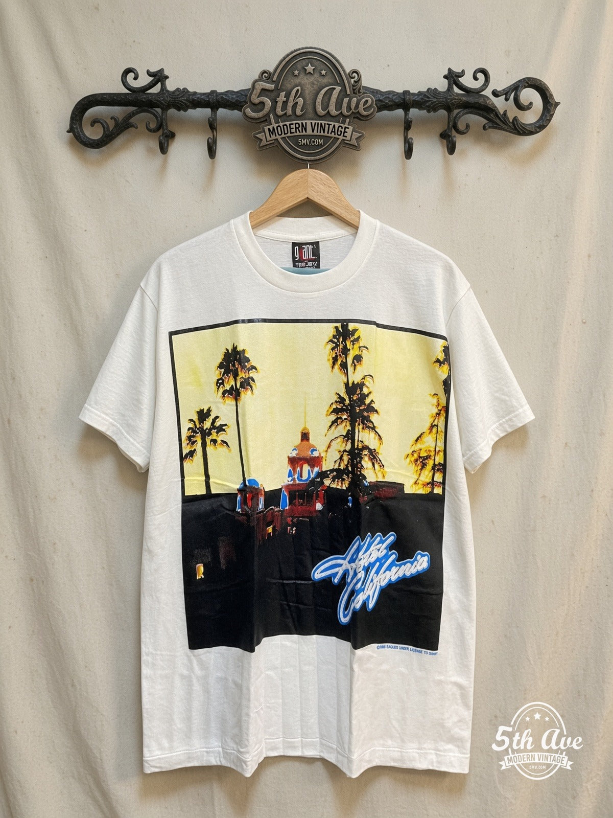 Eagles Hotel California White Tribute Tee – Vintage Band T-Shirt — front on locked cream ornate 5th Ave rack