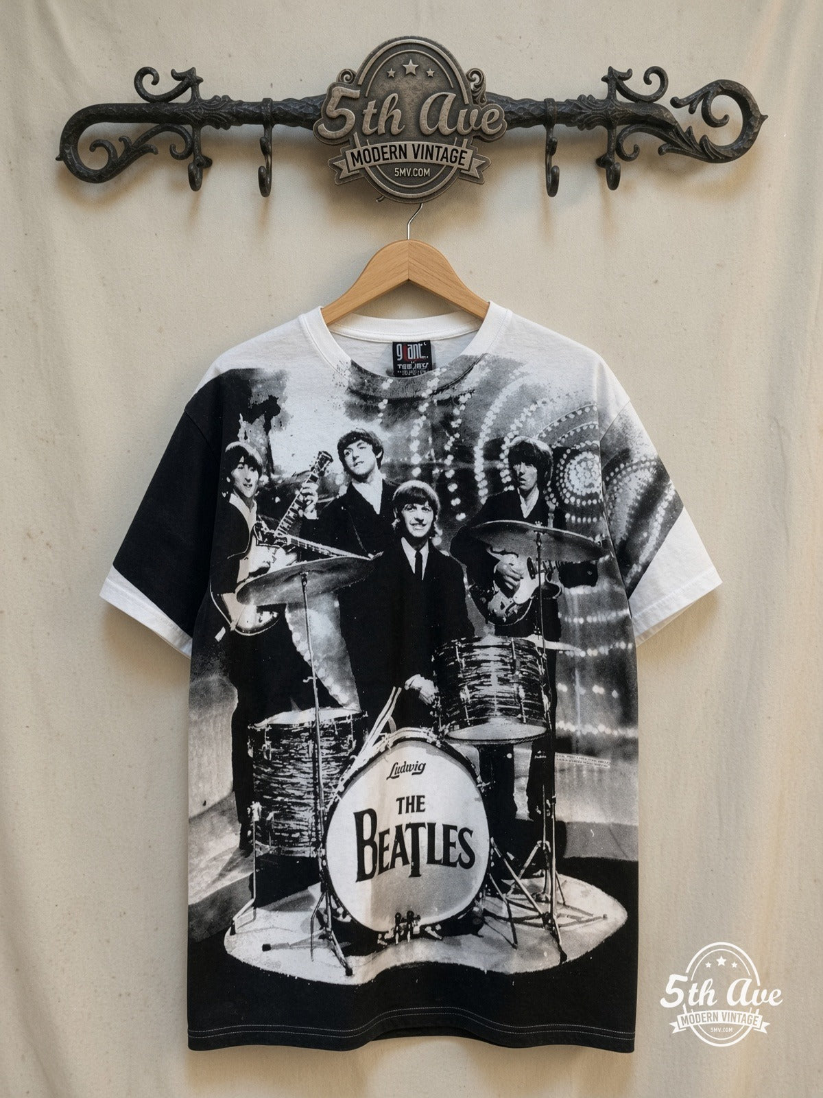 The Beatles – Live Stage Ludwig Drum White All Over Print – Vintage Band T-Shirt — front on locked cream ornate 5th Ave rack