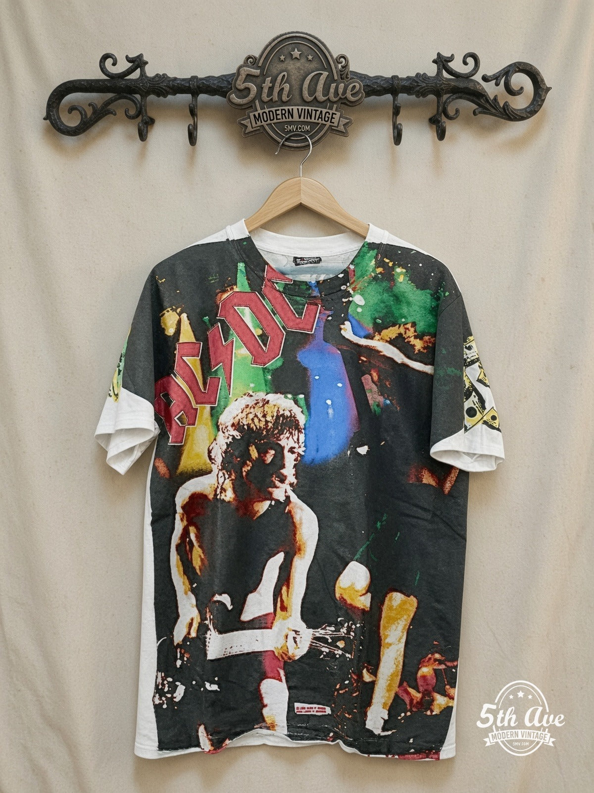 AC/DC – Electrifying Energy: AC/DC All Over Print Single Stitch White t shirt – Vintage Band T-Shirt — front on locked cream ornate 5th Ave rack