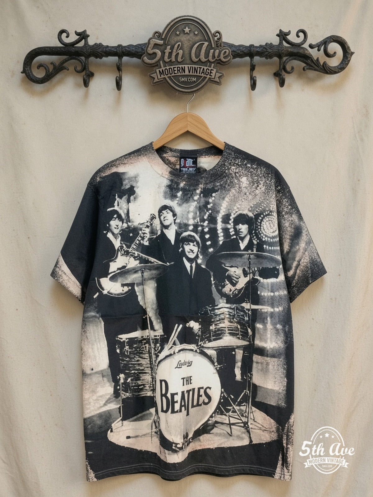 The Beatles – Live Stage Ludwig Drum Black All Over Print – Vintage Band T-Shirt — front on locked cream ornate 5th Ave rack