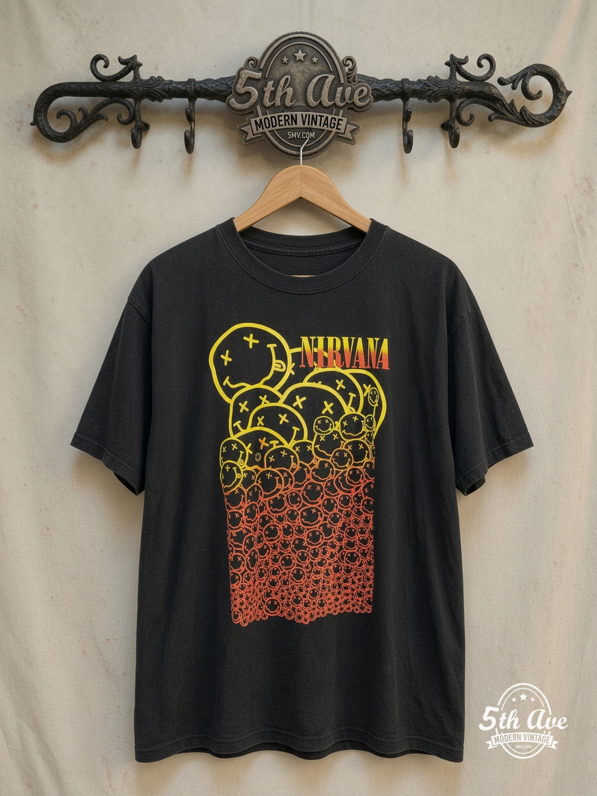 Nirvana – Stacked Gradient Smileys Yellow to Red – Vintage Band T-Shirt — front on locked cream ornate 5th Ave rack