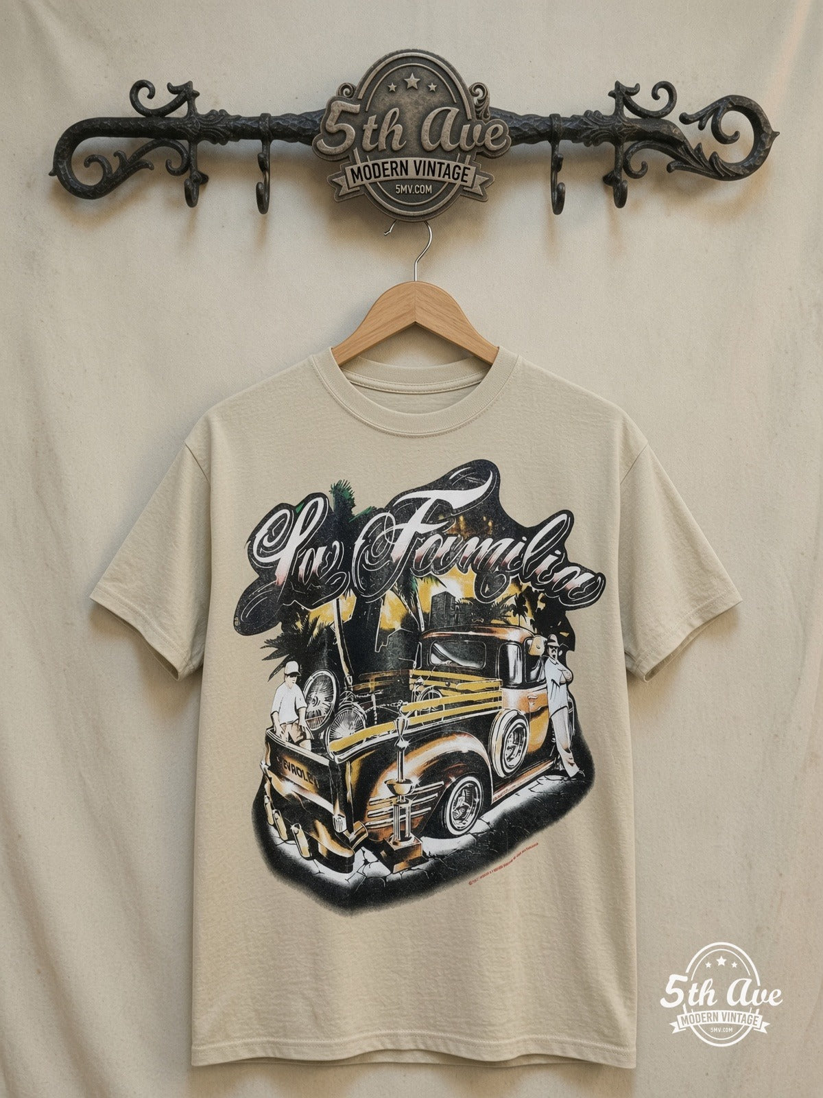 Rollin Hard For Familia Lowrider graphic tee in sand, front view on a display rack