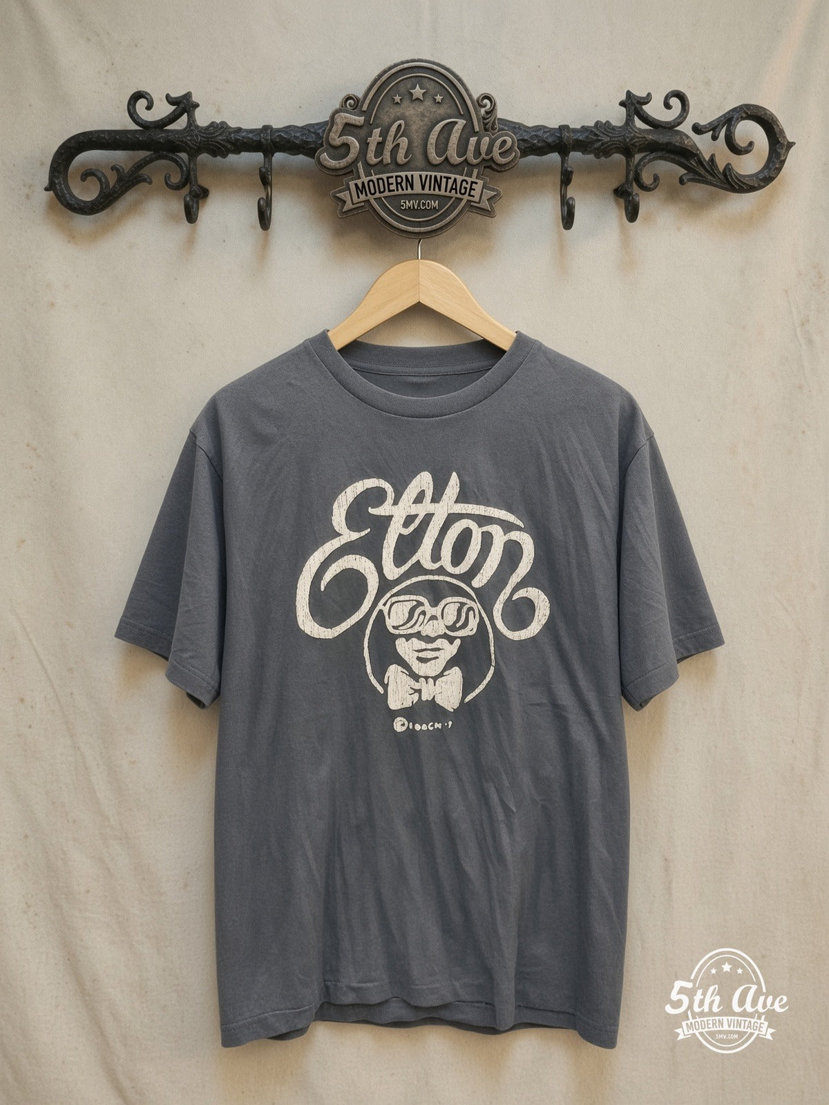 ELTON JOHN 100% Cotton New Vintage Band T-Shirt – Vintage Band T-Shirt — front on locked cream ornate 5th Ave rack