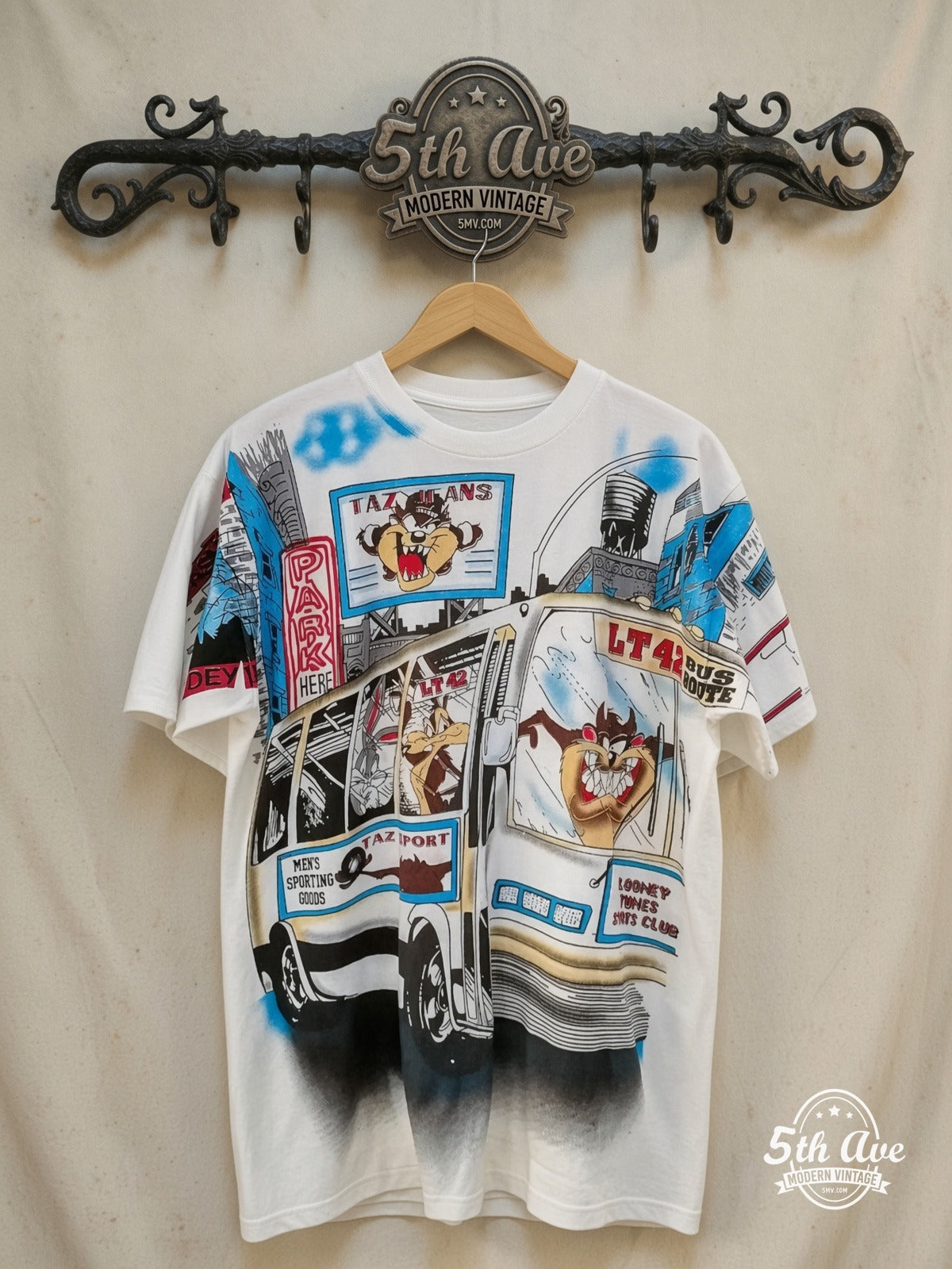 Looney Tunes – On the Move – All Over Print – New Vintage Graphic Tee — front on locked cream ornate 5th Ave rack