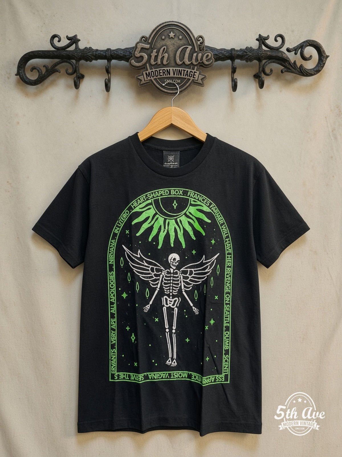 Nirvana – In Utero Tracklist Winged Skeleton – Vintage Band T-Shirt — front on locked cream ornate 5th Ave rack