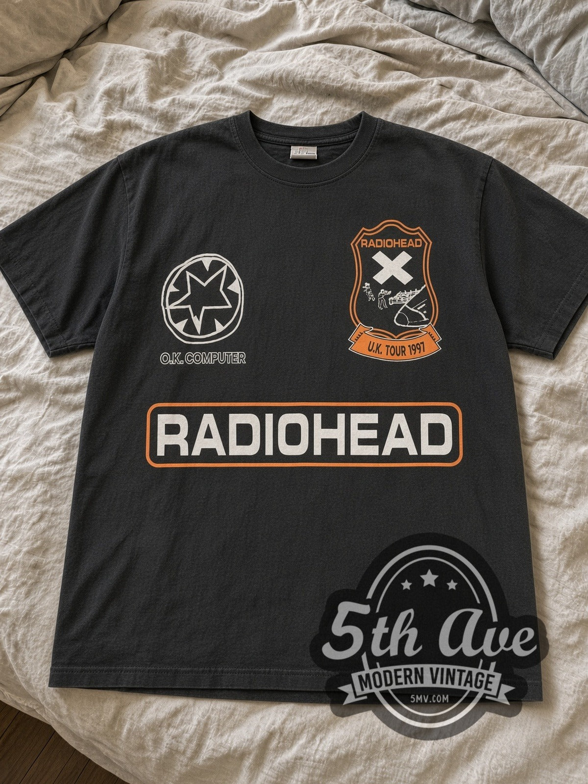 Black Radiohead OK Computer tour tee laid flat on linen bed
