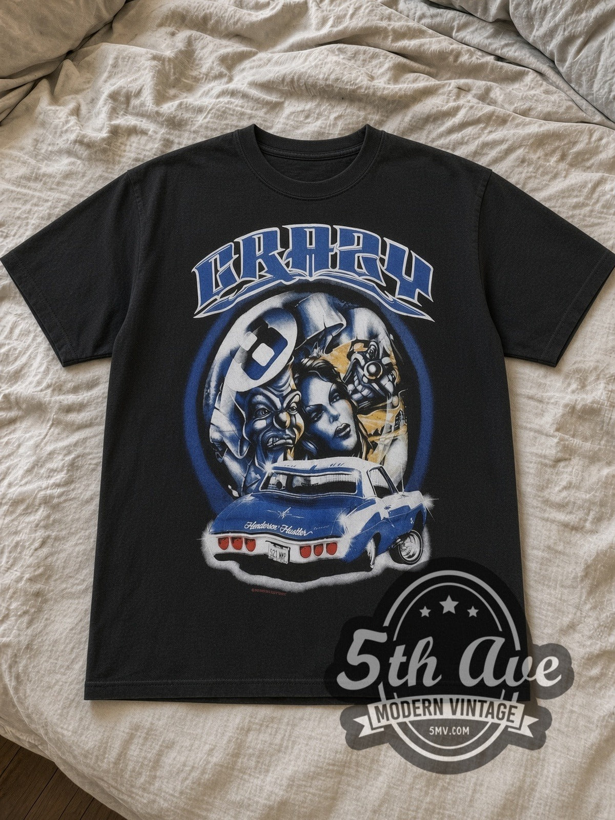 Black Crazy Rollin Hard Lowrider Vintage Graphic T-Shirt laid flat on a linen bed
