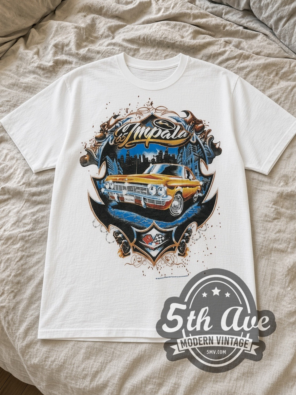 White Rollin Hard '65 Impala Lowrider Vintage Graphic T-Shirt laid flat on a linen bed