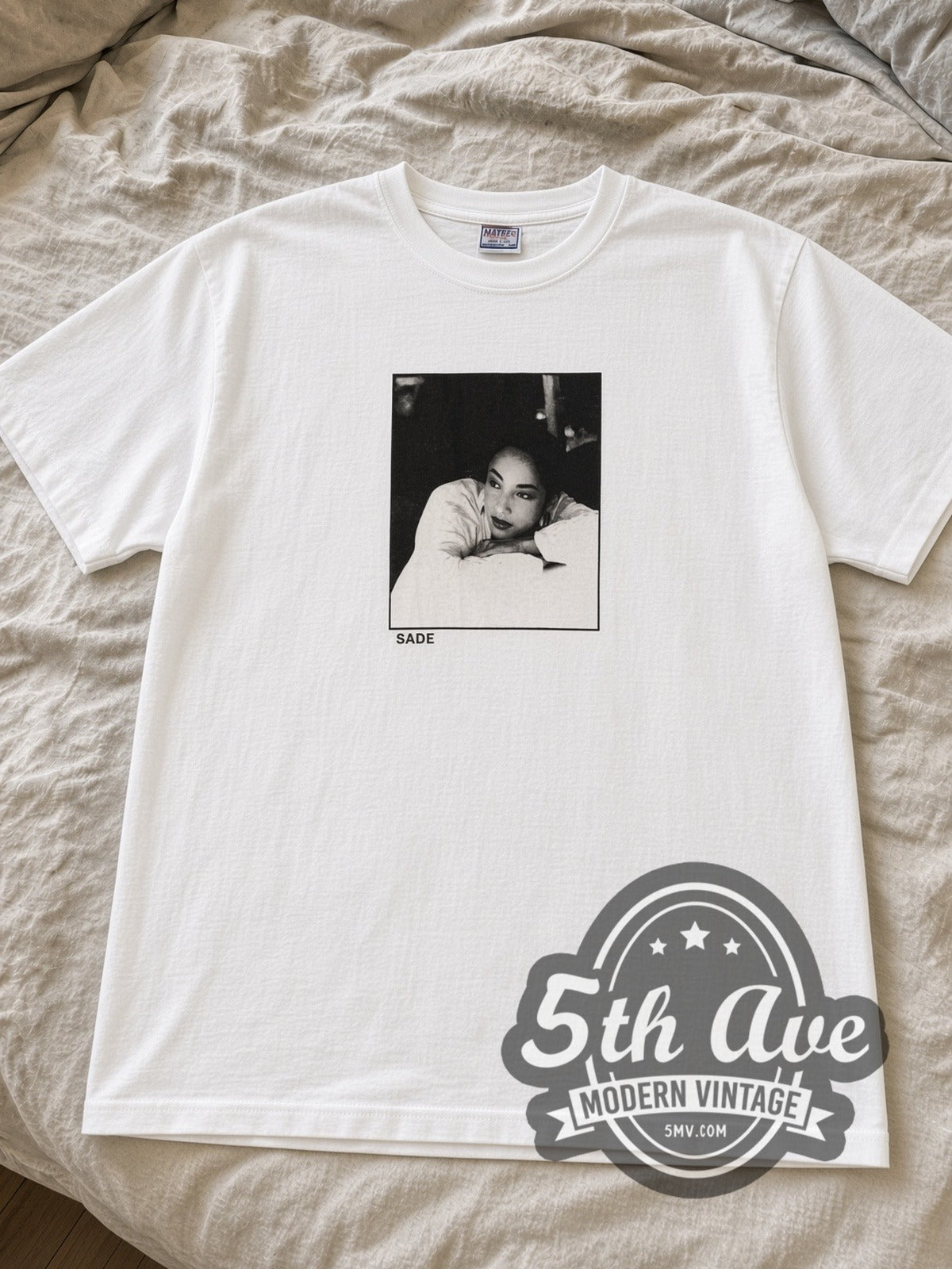 White Sade Stronger Than Pride photo tee laid flat on linen bed