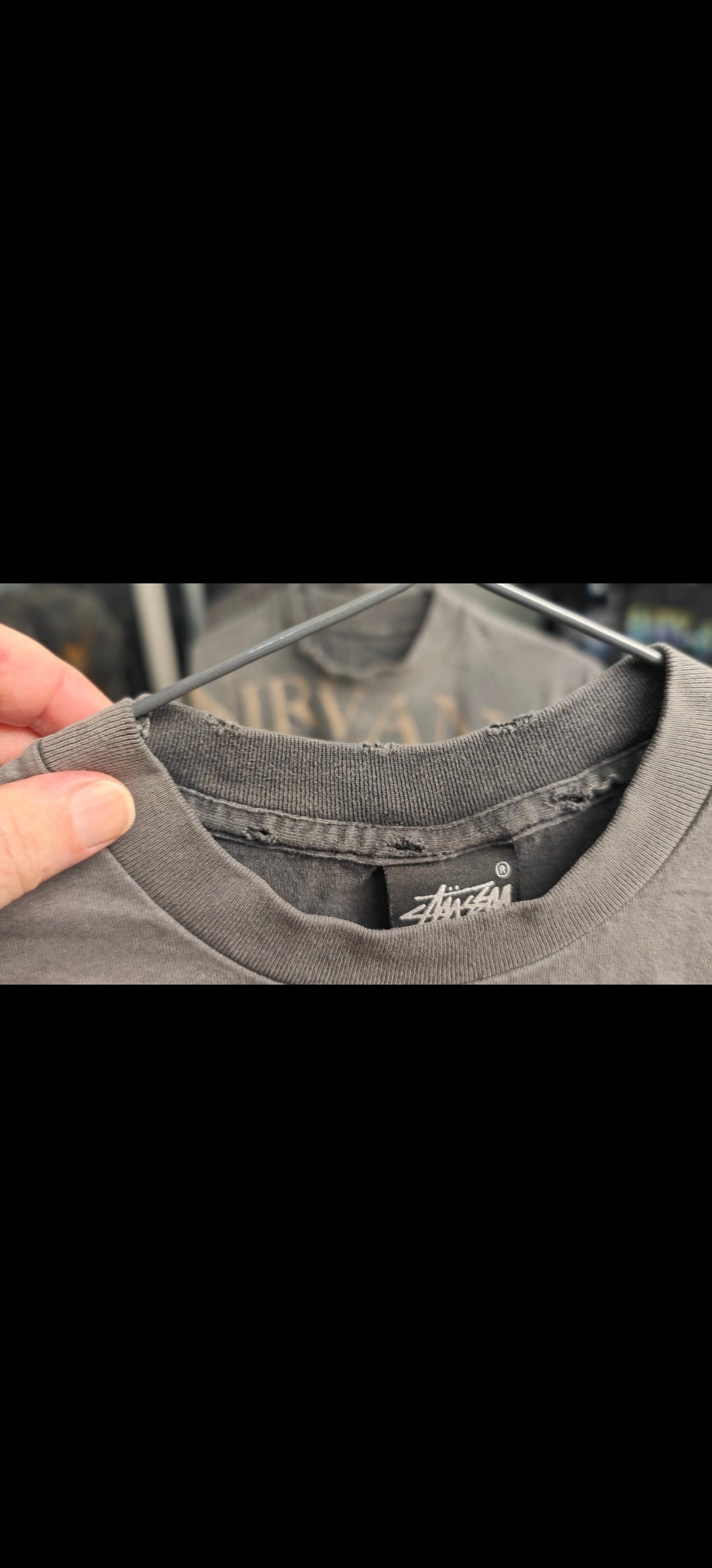 Frayed crewneck collar with intentional wear nicks — shirt distressing close-up
