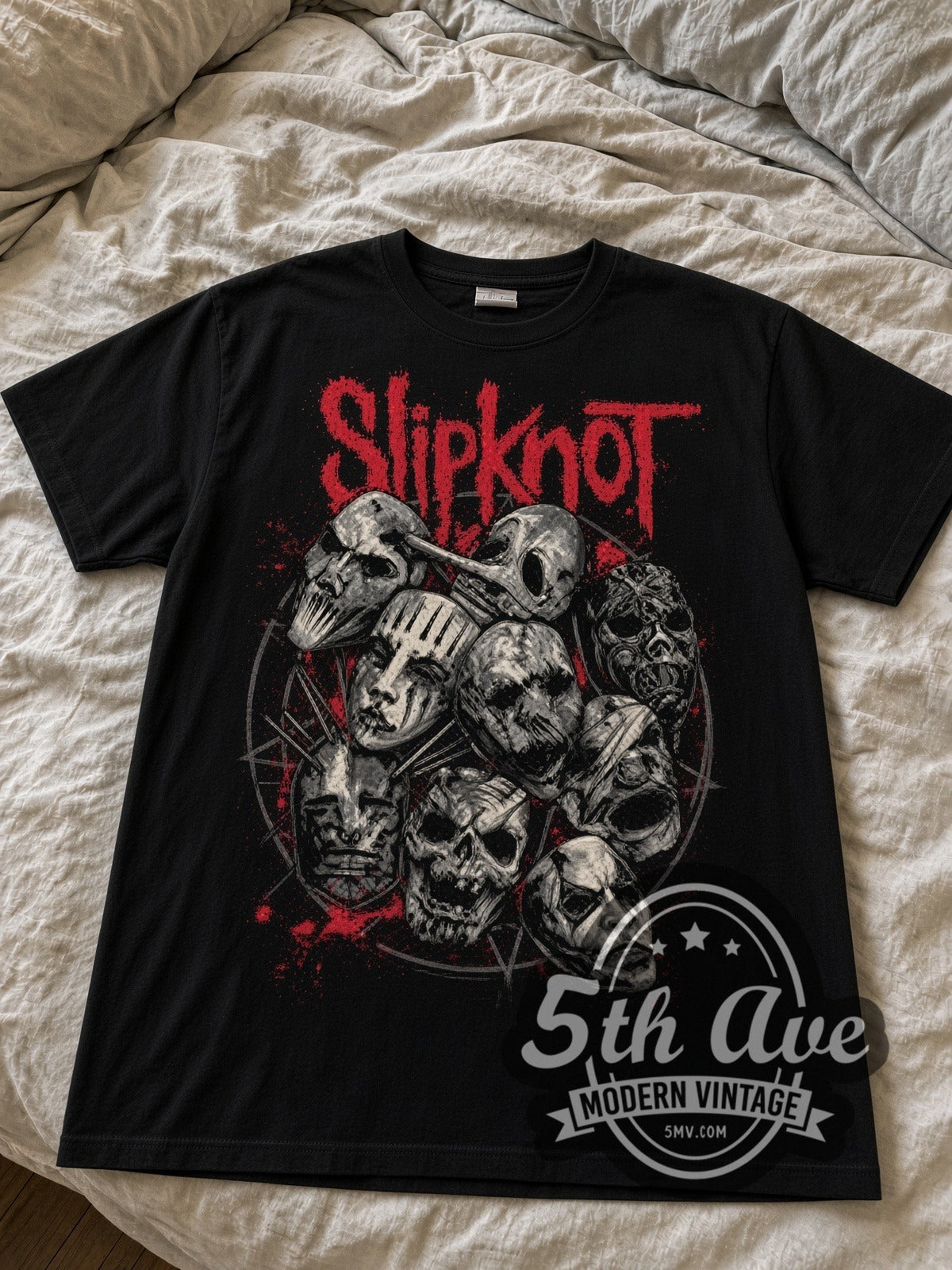 Slipknot Pile of Masks black graphic tee laid flat on linen bed