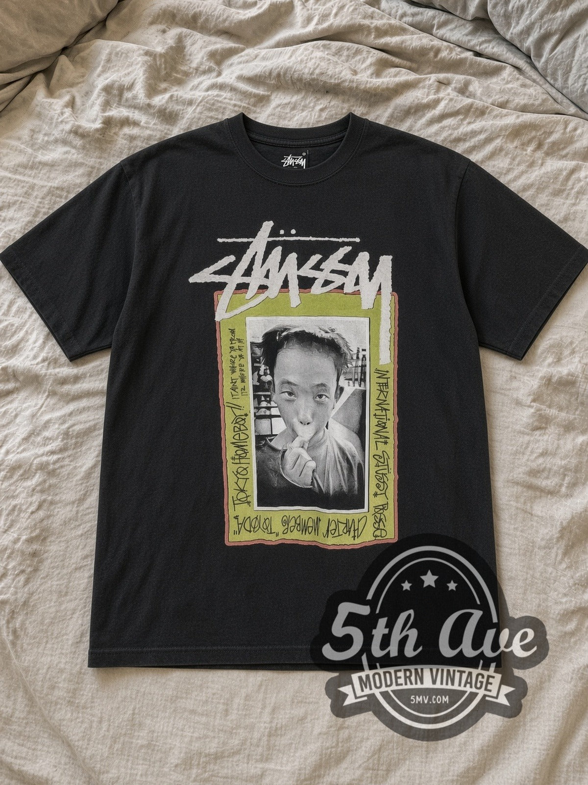 Black Stussy Tokyo Homeboy Toyoda Vintage Graphic T-Shirt laid flat on a linen bed