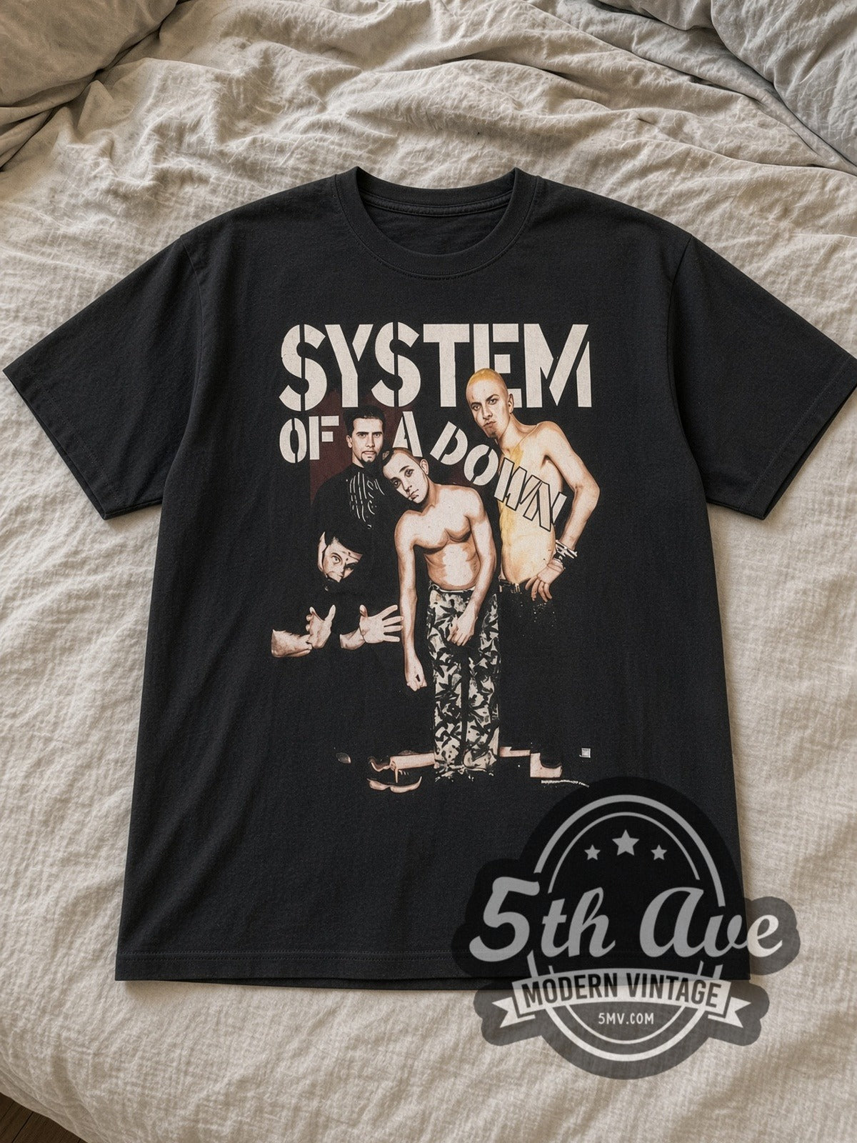 Black System of a Down Sixty Ninth Vintage Band T-Shirt laid flat on a linen bed