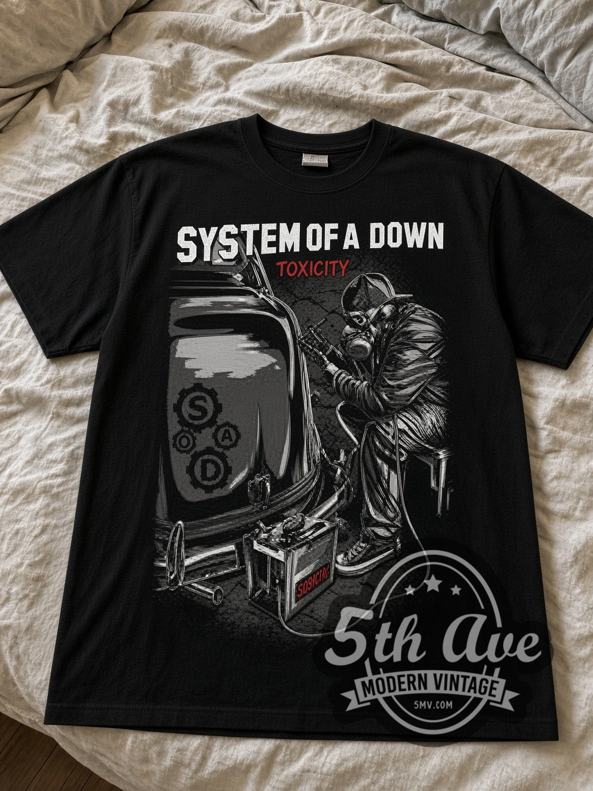 System of a Down Toxicity Mechanic with Car Battery black graphic tee laid flat on linen bed