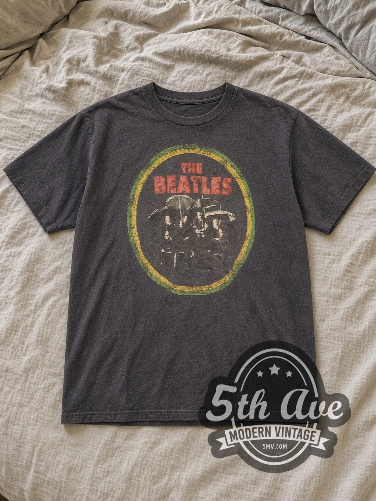 Charcoal The Beatles Circle Logo Band Photo Vintage Band T-Shirt laid flat on a linen bed