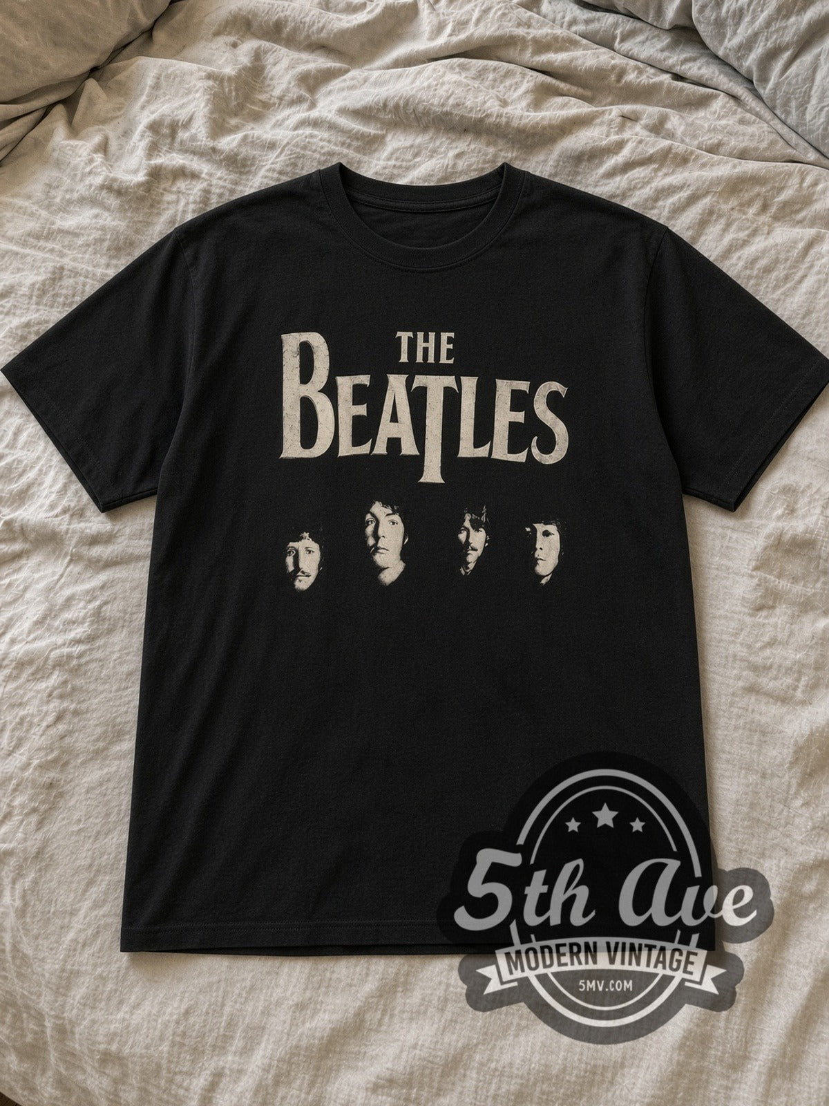 Black The Beatles Four Faces Classic Logo Vintage Band T-Shirt laid flat on a linen bed