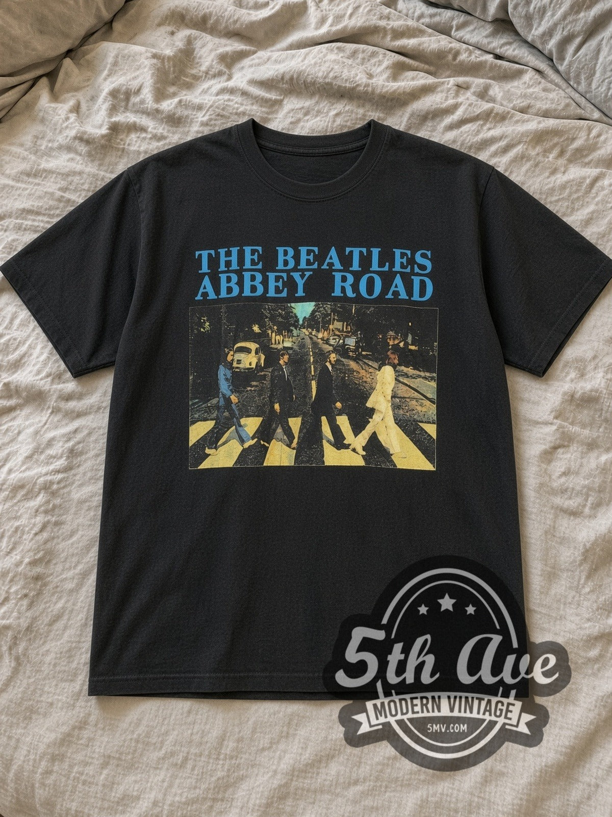 Black The Beatles Abbey Road Crossing Cyan Logo Vintage Band T-Shirt laid flat on a linen bed
