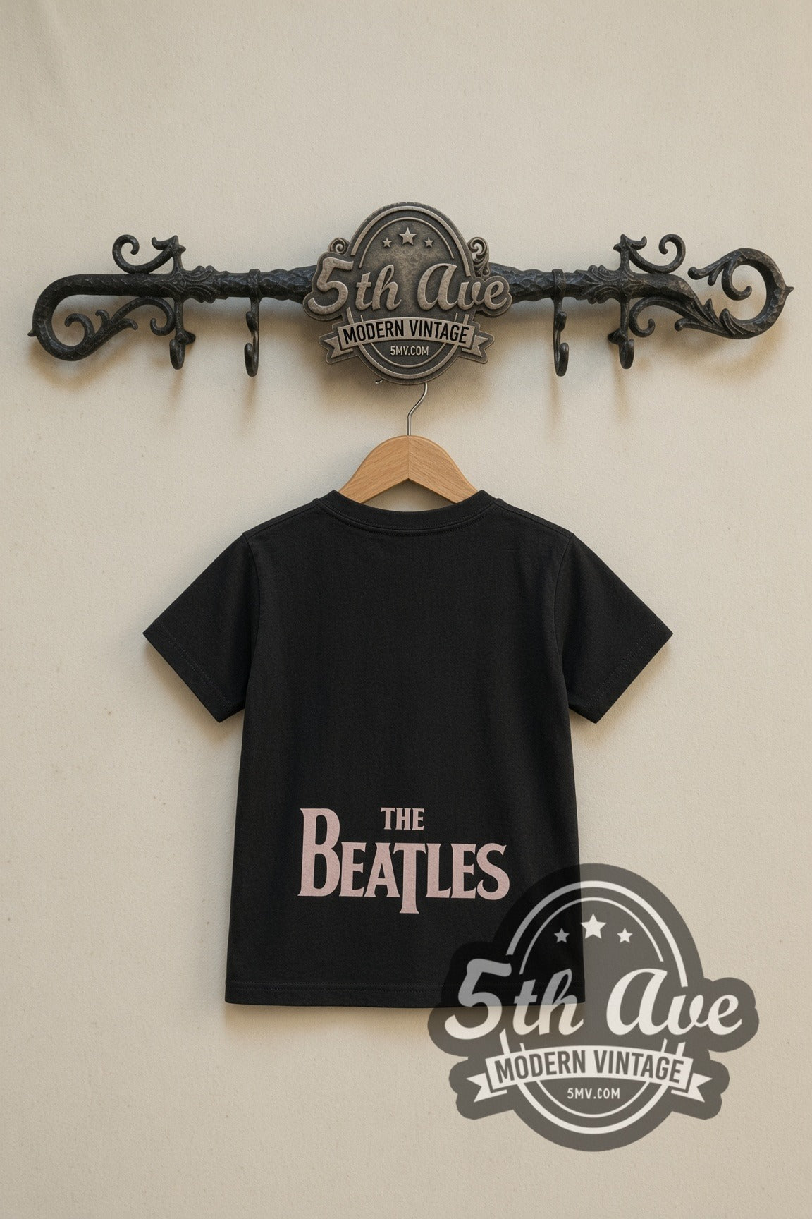 The Beatles Band Photo Logo kids band tee in black, back view on a display rack