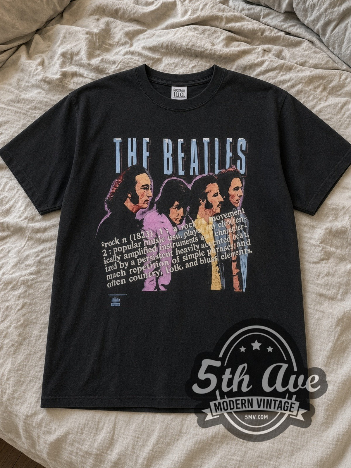Black The Beatles Definition of Rock Vintage Band T-Shirt laid flat on a linen bed