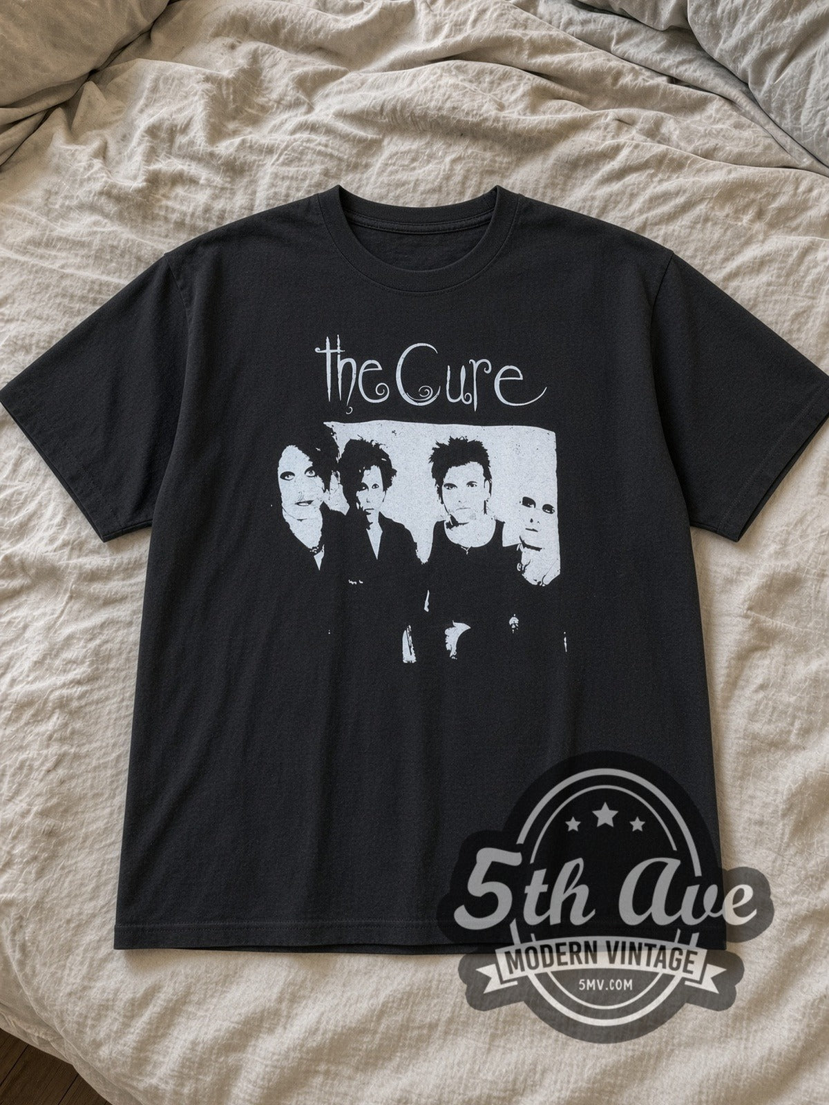 Black The Cure Four Member Photo White Script Vintage Band T-Shirt laid flat on a linen bed