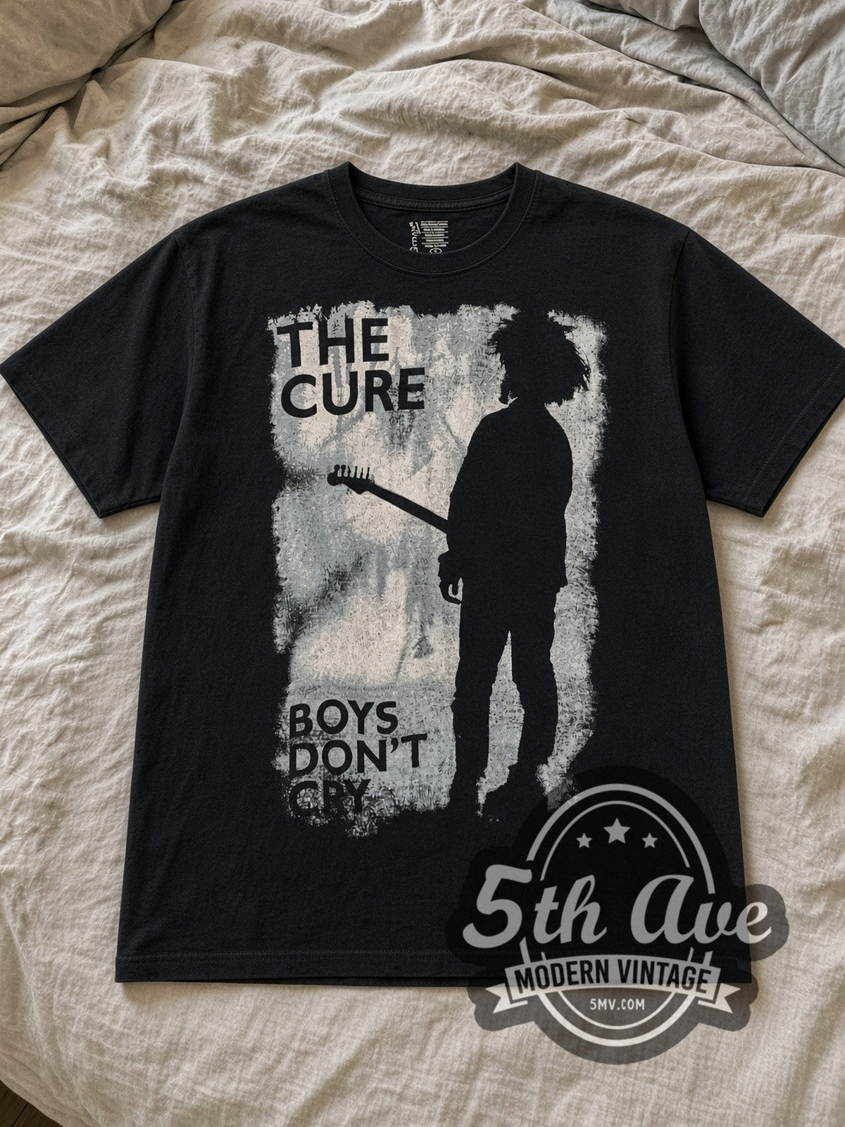 Black The Cure Boys Don't Cry Vintage Band T-Shirt laid flat on a linen bed