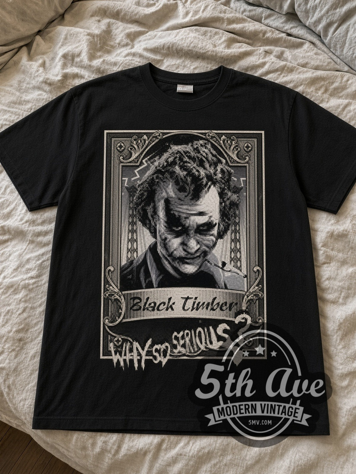 The Dark Knight Joker Black Timber Portrait black graphic tee laid flat on linen bed