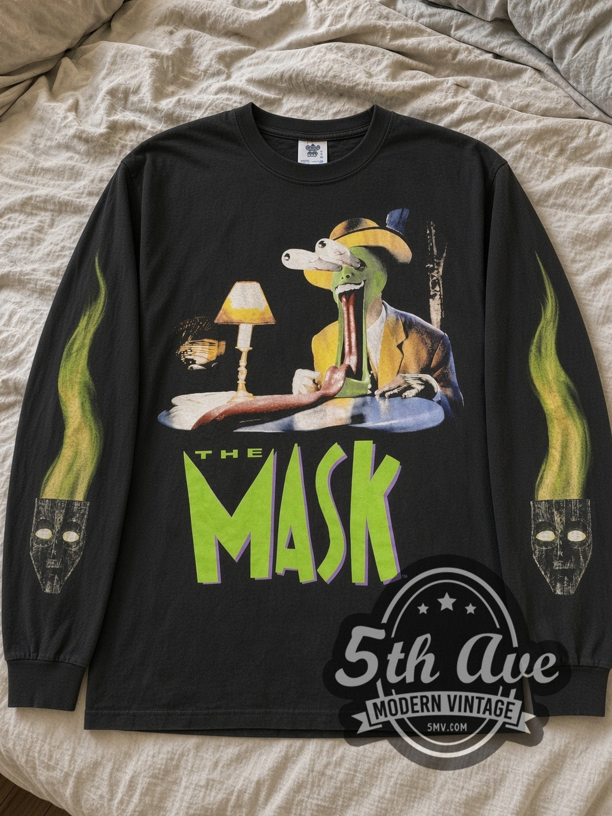 Black The Mask Tongue Out & Milo long sleeve tee laid flat on linen bed