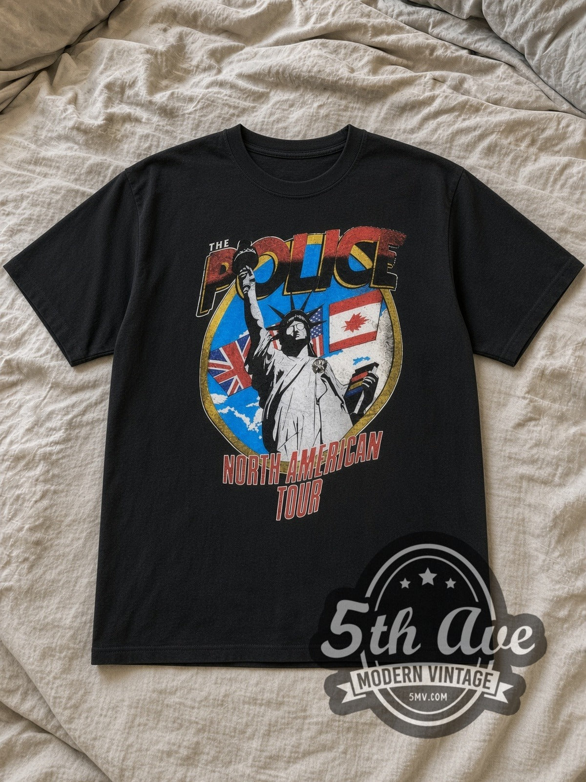 Black The Police North American Tour 1983 Vintage Band T-Shirt laid flat on a linen bed