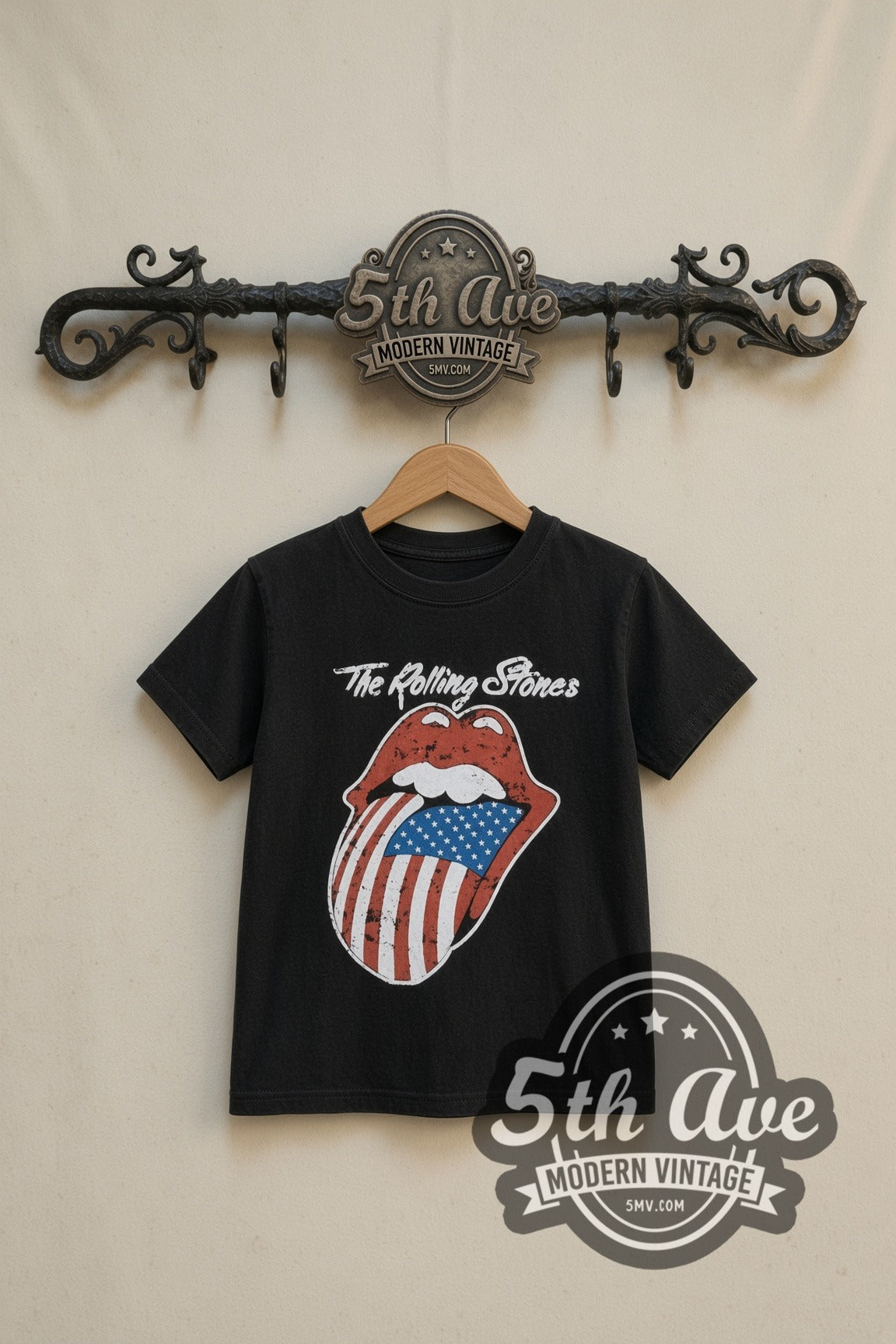 The Rolling Stones American Flag Tongue kids band tee in black, front view on a display rack