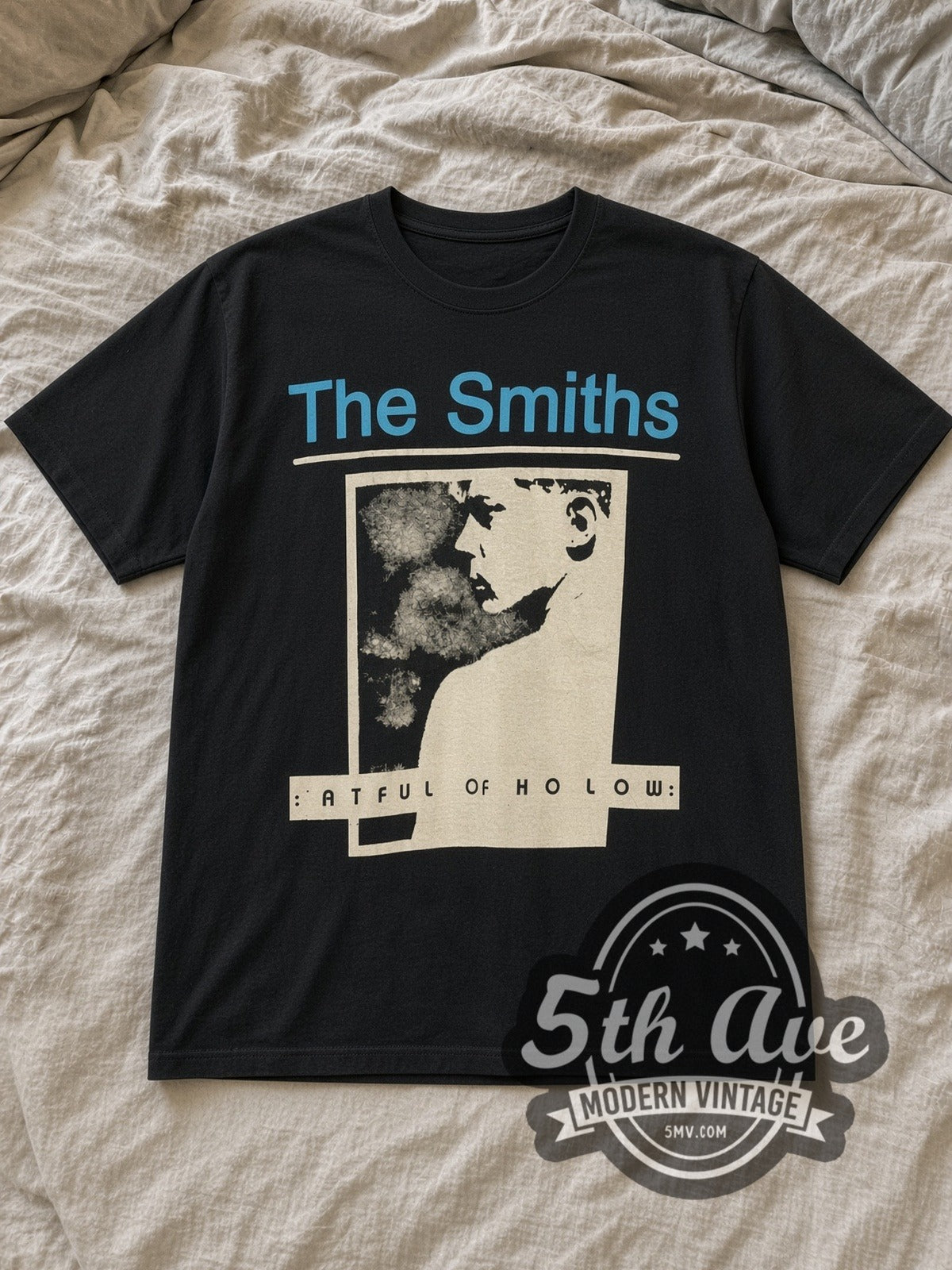 Black The Smiths Hatful of Hollow Blue Header Portrait Vintage Band T-Shirt laid flat on a linen bed