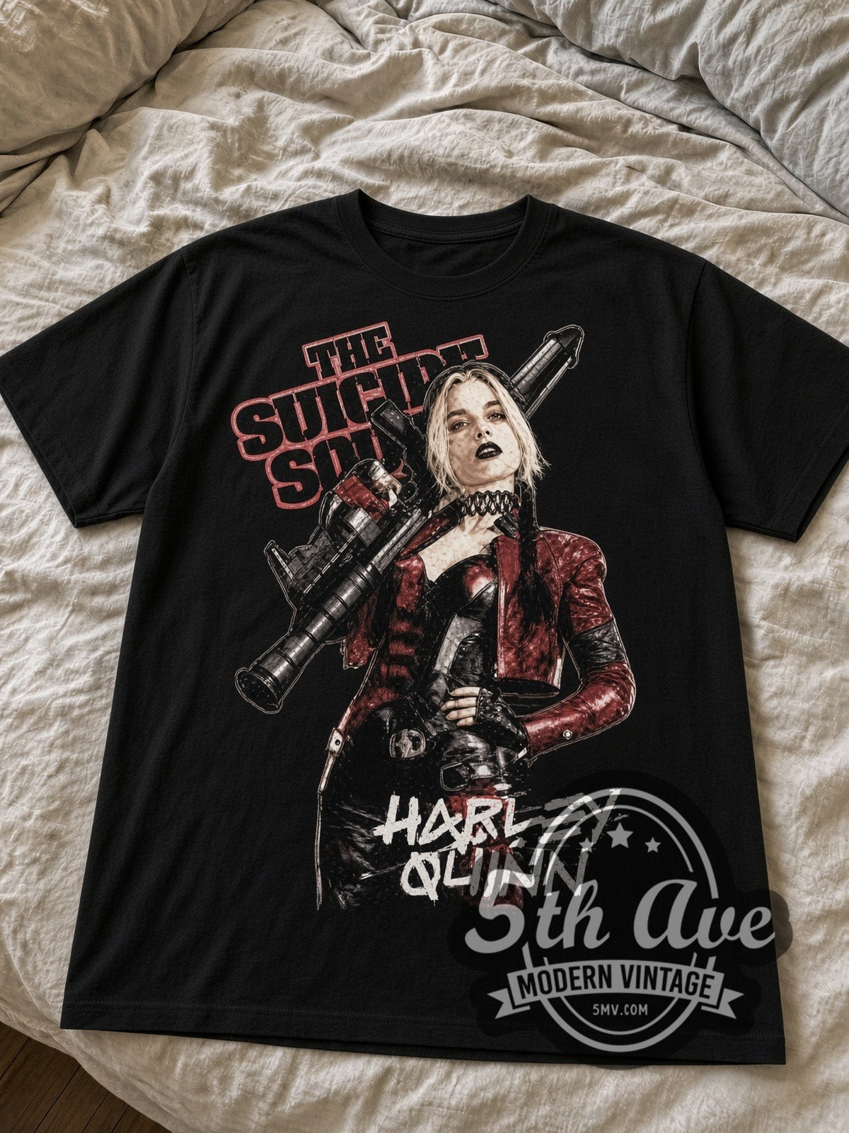 The Suicide Squad Harley Quinn with Bazooka black graphic tee laid flat on linen bed