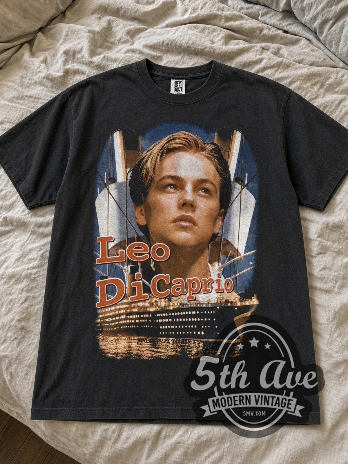 Black Titanic Leo DiCaprio tee laid flat on linen bed