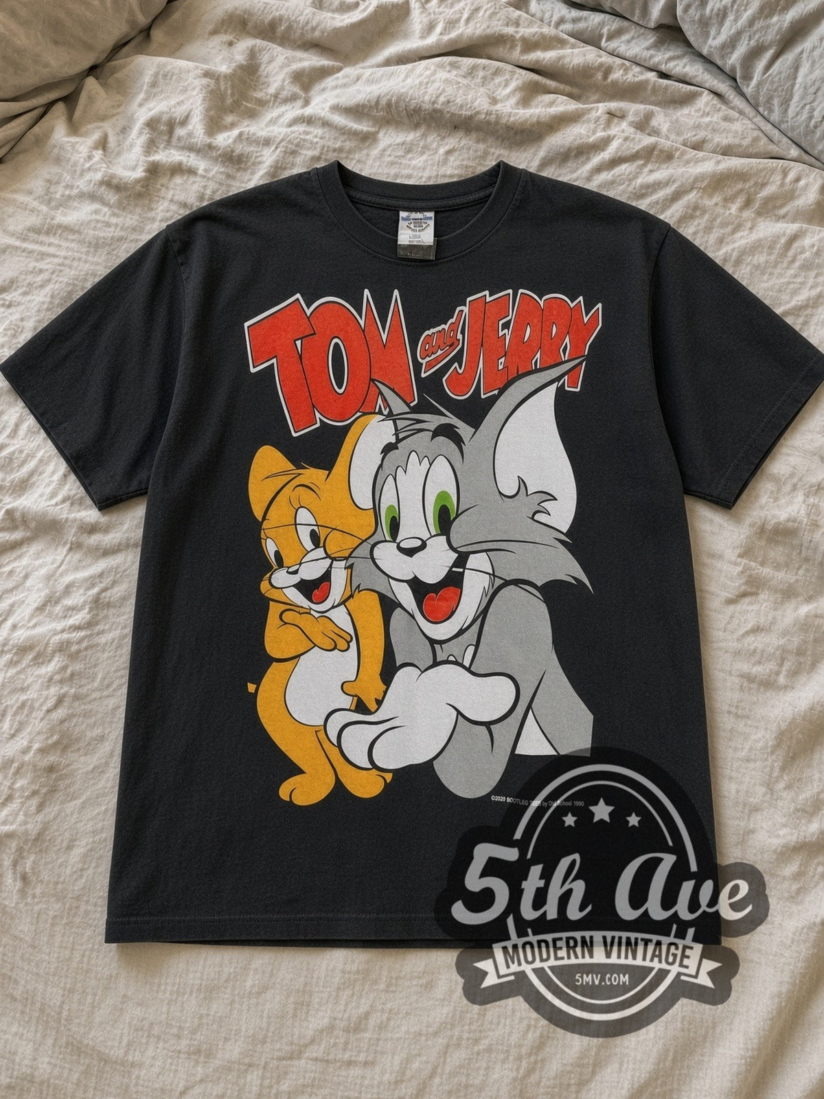 Black Tom and Jerry Vintage Cartoon T-Shirt laid flat on a linen bed
