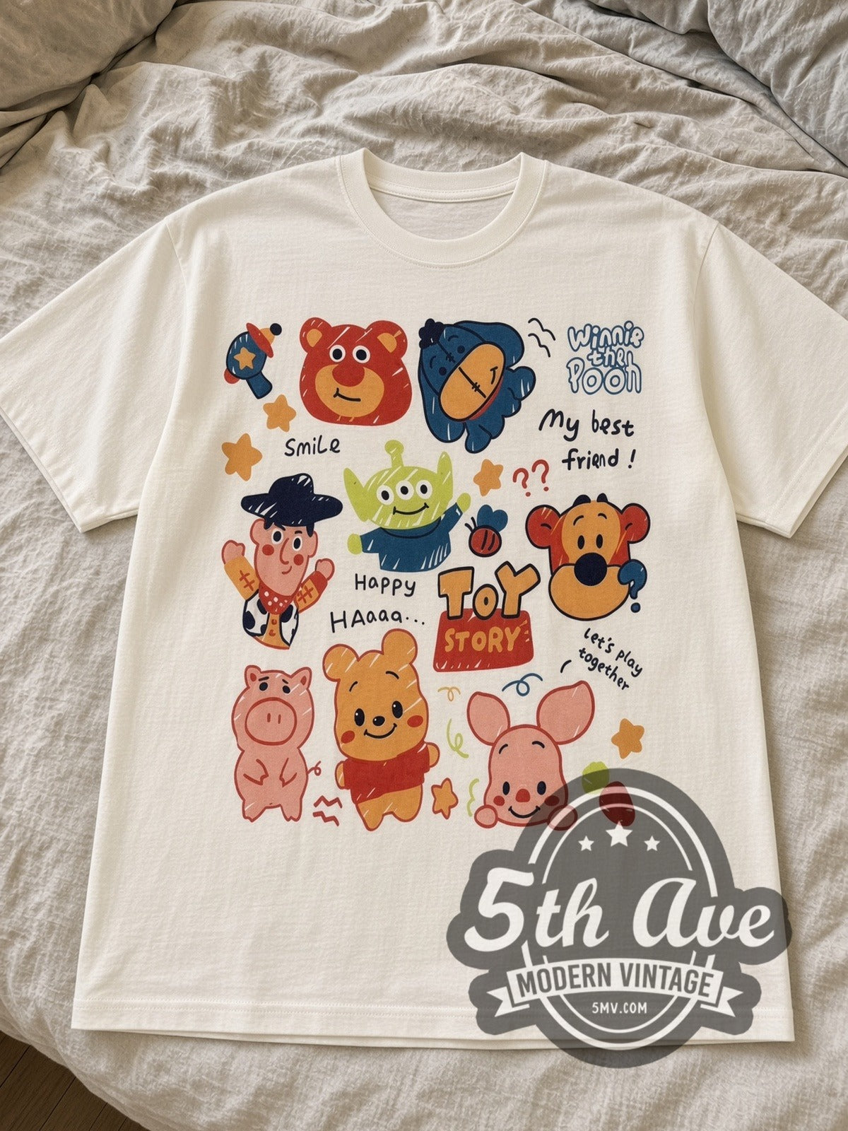 Cream Toy Story & Winnie the Pooh Best Friends Sticker Collage tee laid flat on linen bed