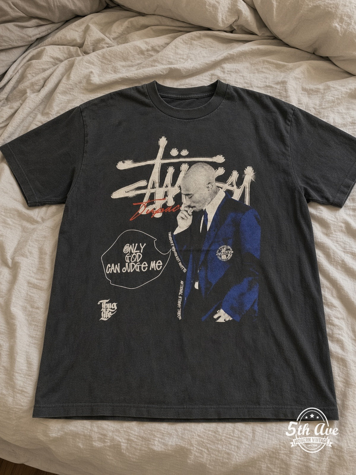 Tupac Stüssy Only God Can Judge Me vintage band tee laid on bed